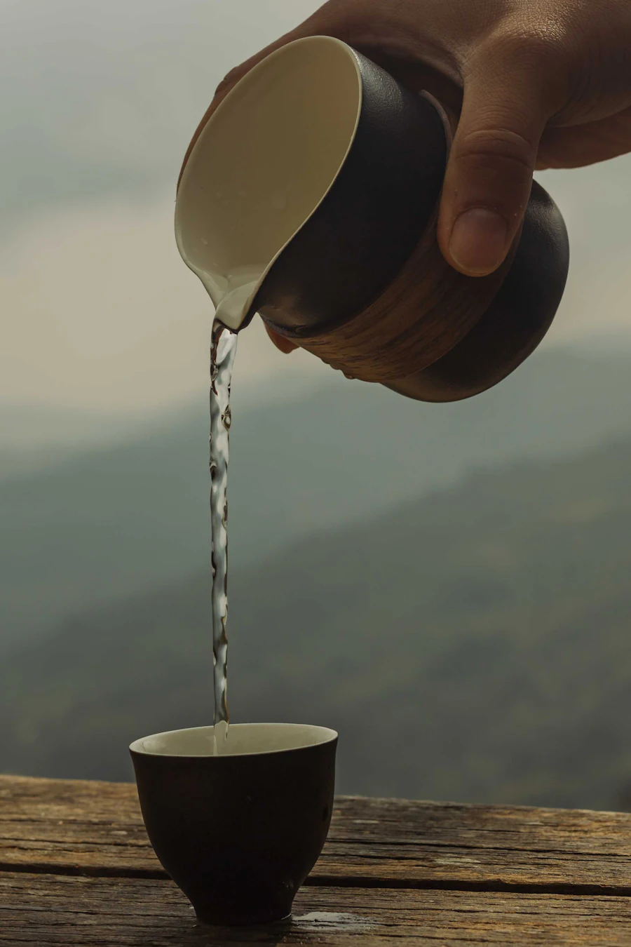 Tea being poured from a small pot into a cup
